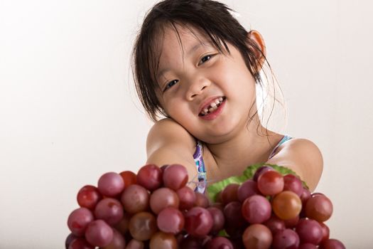 Child is holding grapes in her hands background.