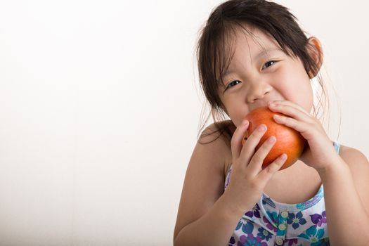 Child is holding an apple in her hands background.
