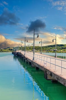 A long concrete pier with lights into the harbor on Antigua