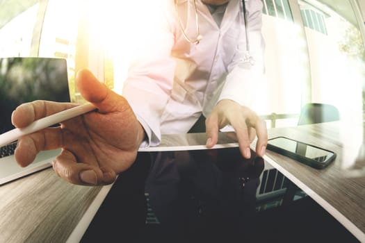 Medicine doctor hand working with modern digital tablet computer with  stethoscope as medical network concept