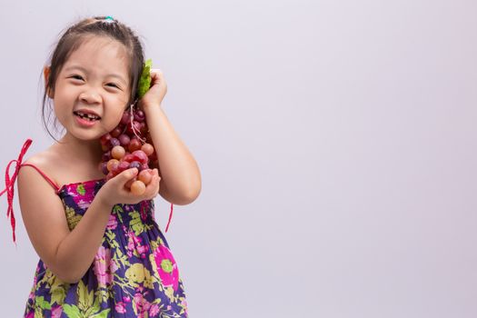 Child is holding grapes in her hand background.