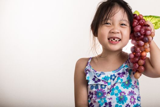 Child is holding grapes in her hand background.