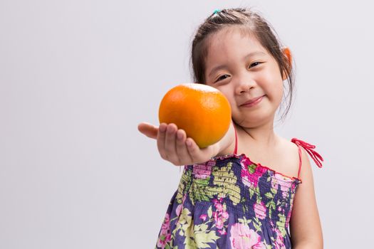 Child is holding orange in her hand background.
