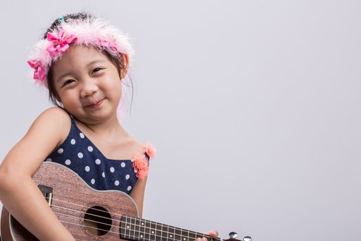 Little girl with her ukulele, string music instrument.