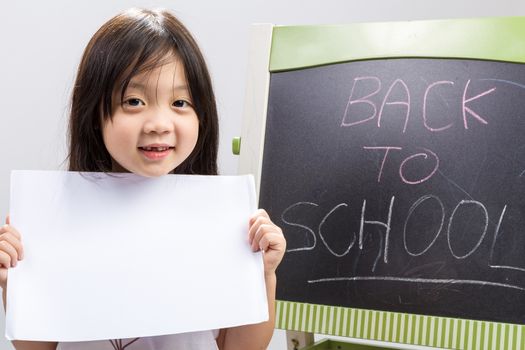 Studio isolated kid holding white sheet of blank paper.