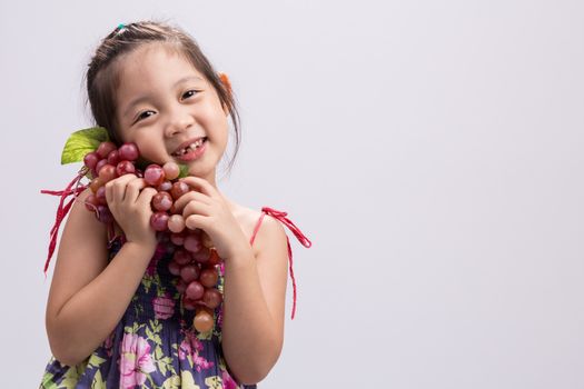 Child is holding grapes in her hand background.