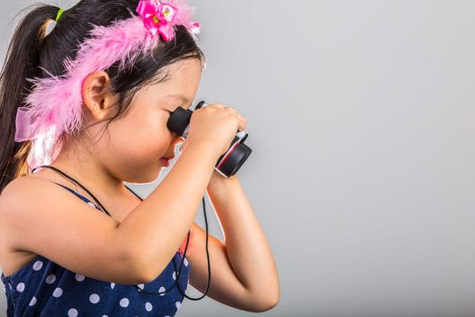 Young Asian girl looking through binoculars.