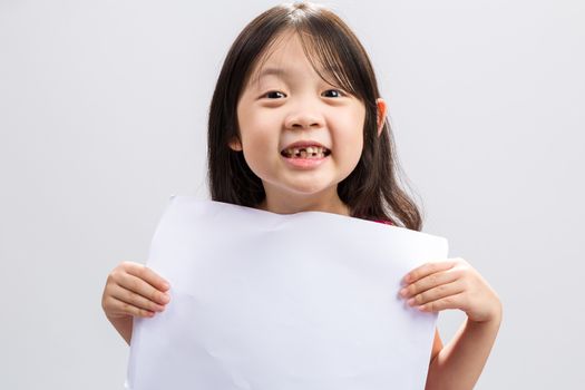 Studio isolated kid holding white sheet of blank paper.