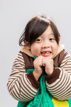 Cute Asian girl shivering in coat, studio isolated white background.