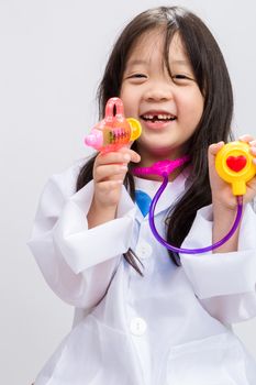 Young little girl dressing doctor with medical instrument in hands.