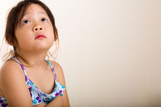 Little girl with lonely emotion sitting alone by herself.