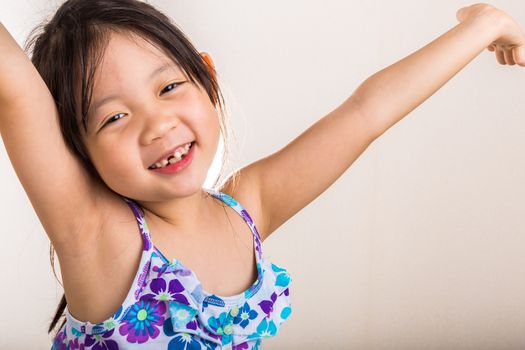 Little girl stretches in the morning after woke up.