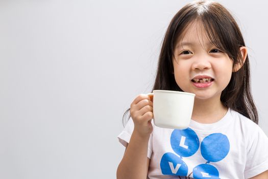 Kid drinking milk on studio isolated white background.