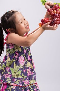 Child is holding grapes in her hand background.