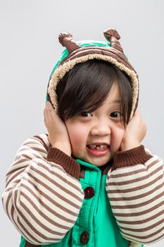 Cute Asian girl shivering in coat, studio isolated white background.