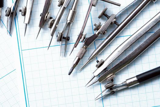 Set of old drawing tools on background with graph paper