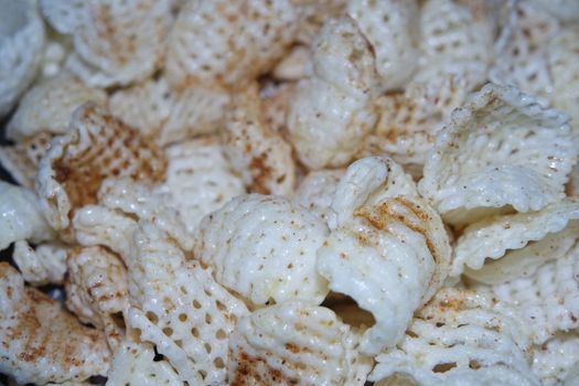 Closeup view of freshly fried chips as fast food for tea break. Potato chips with spices sprinkled on it. Fast food background for advertisements.