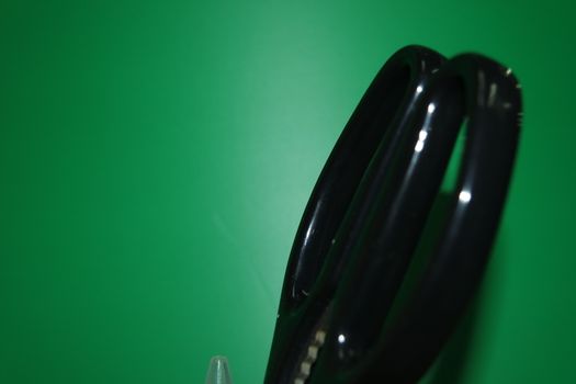 Closeup view of a stationery pot containing stationery items. stationery pot in front of a green background.