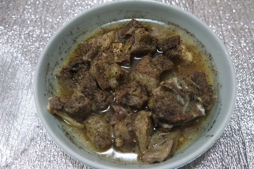 Top view of siri paaye or paya dish garnished with diced ginger, long coriander and black pepper. This dish is popular in Pakistan and Bangladesh