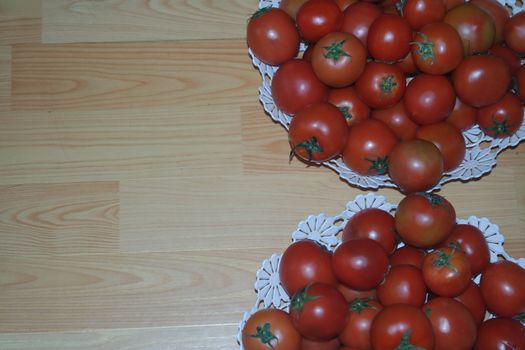 Close-up view of red tomatoes in white basket on a wooden floor in market for sale. A fruit background for text and advertisements