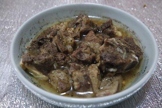 Top view of siri paaye or paya dish garnished with diced ginger, long coriander and black pepper. This dish is popular in Pakistan and Bangladesh