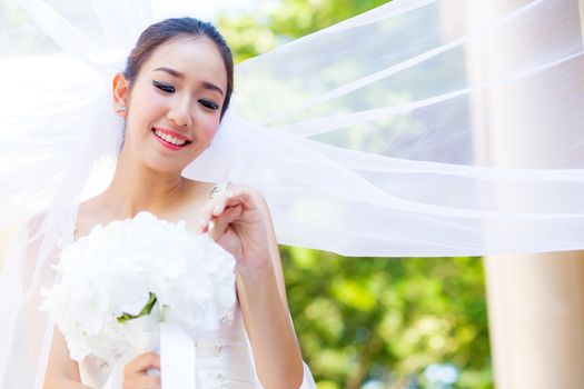 beautiful young woman on wedding day in white dress in the garden. Female portrait in the park.