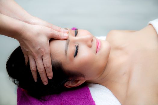 Beautiful woman is getting a facial massage in the spa salon