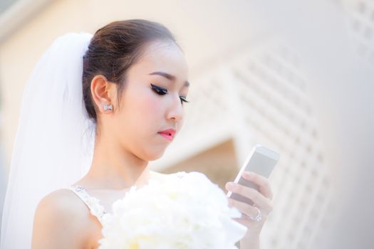 bride talking on cell phone in wedding dress