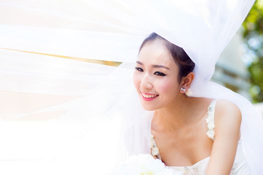 beautiful young woman on wedding day in white dress in the garden. Female portrait in the park.