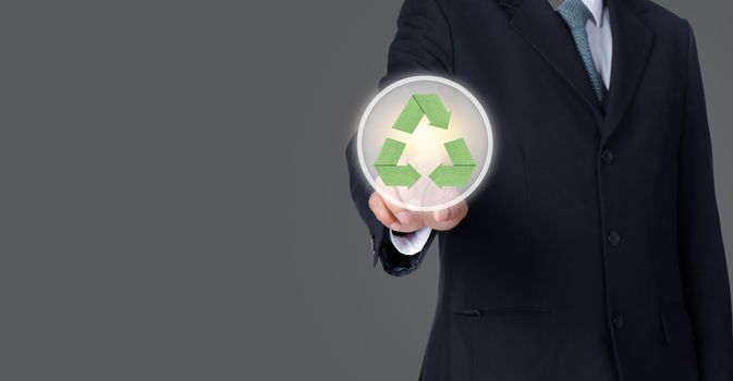 business man pointing at green recycle symbol with gray background