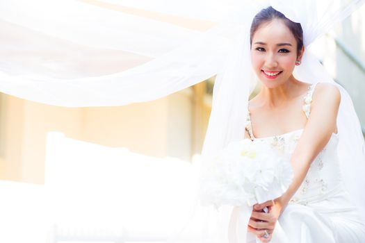 beautiful young woman on wedding day in white dress in the garden. Female portrait in the park.