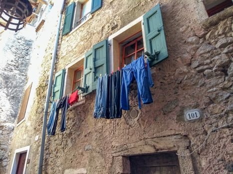 Old traditions in Europe: clothes hung out to dry under a window of a stone house in an ancient Italian village