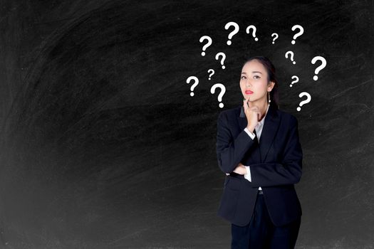 woman is standing with question marks blackboard background