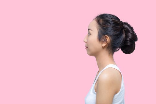 side view of beautiful woman with perfect skin isolated on pink background