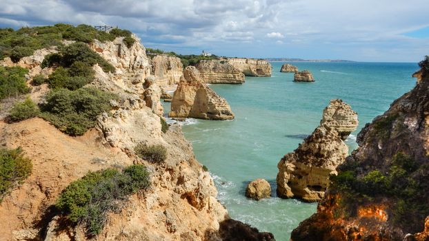 Panoramic view of the Algarve ocean cliffs, Portugal, with cloudy dramatic sky