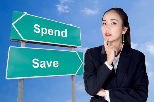 Spend save road sign with business woman thinking choice direction