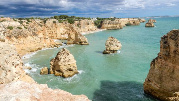 Panoramic view of the Algarve ocean cliffs, Portugal, with cloudy dramatic sky