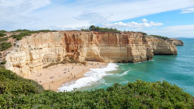 Panoramic view of the ocean cliffs of the Algarve, Portugal, with cloudy blue sky