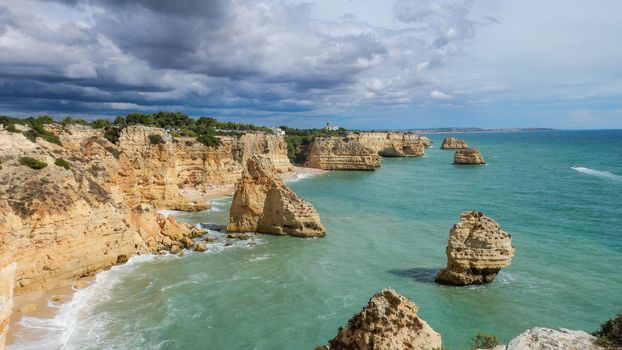 Panoramic view of the Algarve ocean cliffs, Portugal, with cloudy dramatic sky