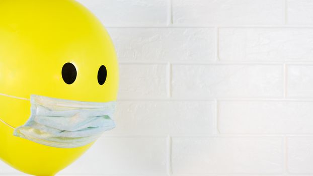 Yellow balloon one in a medical mask with copy space quarantined in case of an epidemic of virus,flu,Allergy or covid19.Preventing the development of an outbreak of infection and a pandemic.Pneumonia