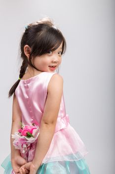 Rear view of cute Asian girl holding flower.