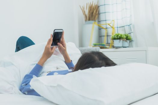 woman wake up and use phone on bed