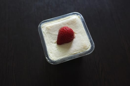 Tasty cupcake with strawberry on black wooden background . Copy space. Place for text.
