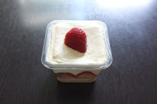 Tasty cupcake with strawberry on black wooden background . Copy space. Place for text.