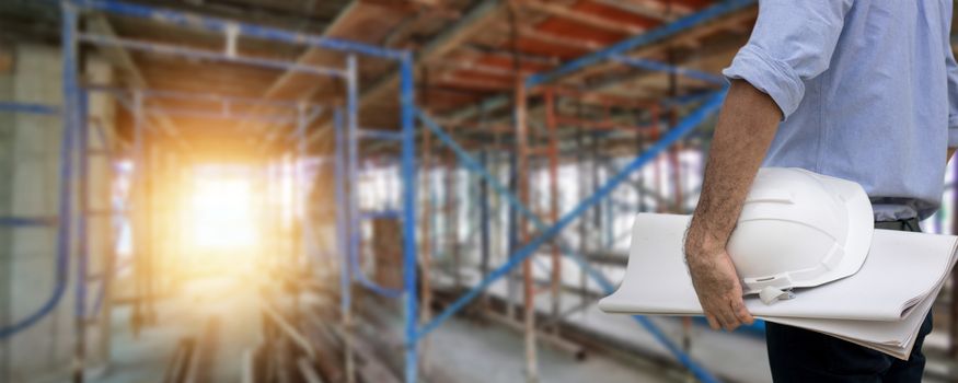 business engineer portrait holding helmet and blue print at construction site working, inspector concept