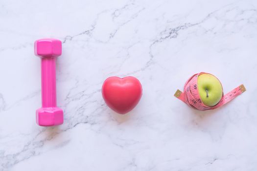 Dumbbell with red heart shape and green apple, healthy and fitness concept