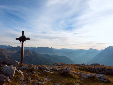 Iron cross at mountain top in alp. Cross on top of a mountains peak as typical in the Alps. Monument to the dead climbers