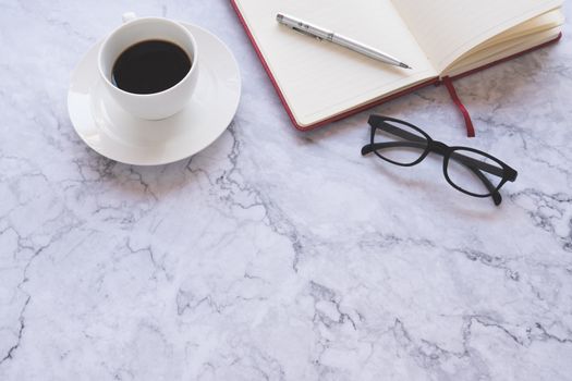 Flat lay creative and designer background with cup of coffee and office tools on white marble background 