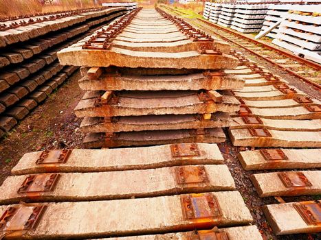 Extracted old concrete sleepers in stock. Old  rusty used concrete railway ties stored after big reconstruction of old railway station. 