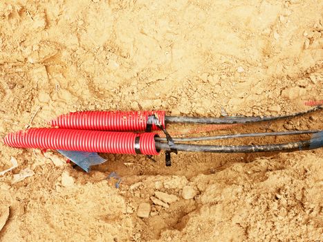 Wire in HDPE and protectivep tube. Building of lines of metallic and fiber optic cables, construction of communication optical network connection. Excavation of trench by hand or mechanized excavator and installation.